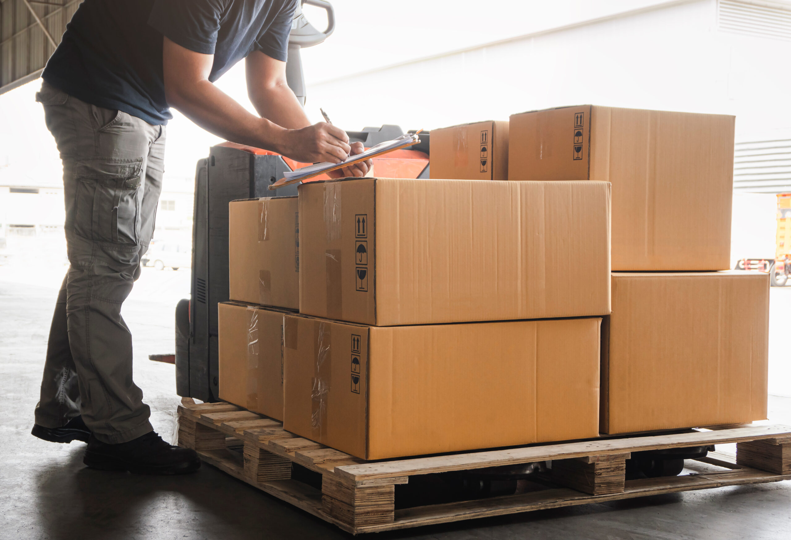 Workers,Holding,Clipboard,Is,Checking,Stock,Of,Package,Boxes.,Storage